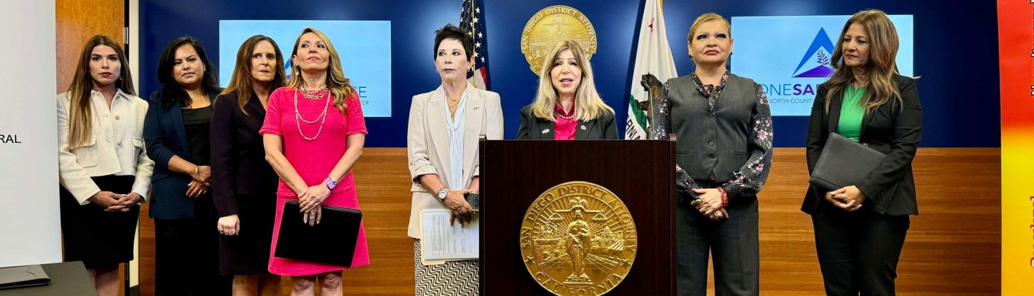 District Attorney Summer Stephan stands at a podium for a press conference with the Consulate General of Mexico Alicia Kerber-Palma, Attorney General of Baja California Maria Elena Andrade, the Director of Baja California Justice Center for Women Magdalena Bautista, and the Director of One Safe Place: The North County Family Justice Center Claudia Grasso.