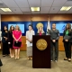 District Attorney Summer Stephan stands at a podium for a press conference with the Consulate General of Mexico Alicia Kerber-Palma, Attorney General of Baja California Maria Elena Andrade, the Director of Baja California Justice Center for Women Magdalena Bautista, and the Director of One Safe Place: The North County Family Justice Center Claudia Grasso.