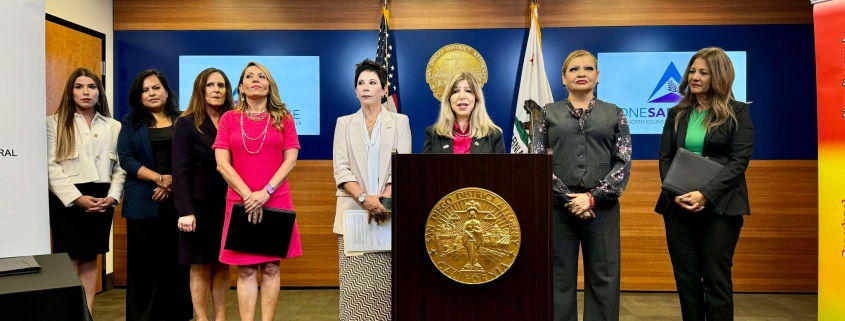 District Attorney Summer Stephan stands at a podium for a press conference with the Consulate General of Mexico Alicia Kerber-Palma, Attorney General of Baja California Maria Elena Andrade, the Director of Baja California Justice Center for Women Magdalena Bautista, and the Director of One Safe Place: The North County Family Justice Center Claudia Grasso.