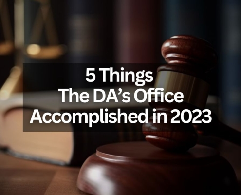 Text that says "5 Things the DA's Office Accomplished in 2023" with the background of a gavel, scales of justice and a few books on a table.