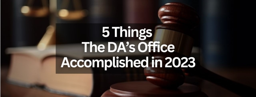 Text that says "5 Things the DA's Office Accomplished in 2023" with the background of a gavel, scales of justice and a few books on a table.