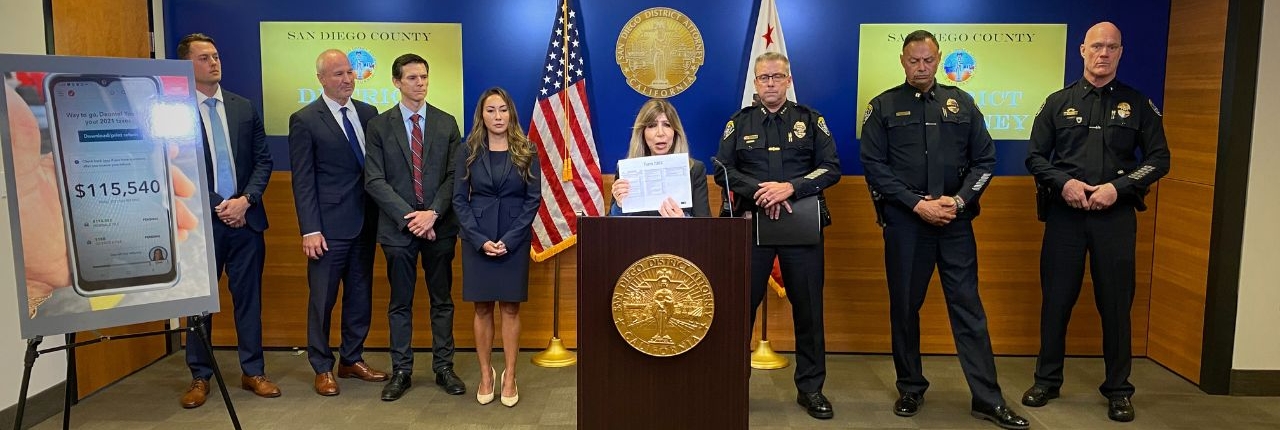 During a news conference,DA Summer Stephan holds up the Tax Form used by gang members accused of COVID Tax Fraud.