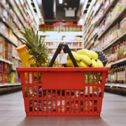 Photo of grocery basket on the floor of a food isle in a grocery store.