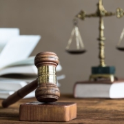 Photo of a gavel over law books and scales of justice.