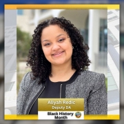 Foto de la Fiscal Auxiliar Aliyah Redic, para el Mes de la Historia Afroamericana. El edificio del Palacio de Justicia esta en el fondo de la foto.