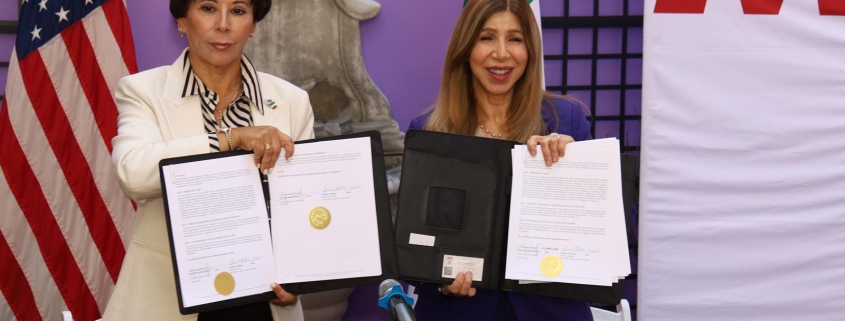 Photo of Ambassador Alicia Kerber Palma and District Attorney Summer Stephan holding MOU after the MOU signature cermeony.