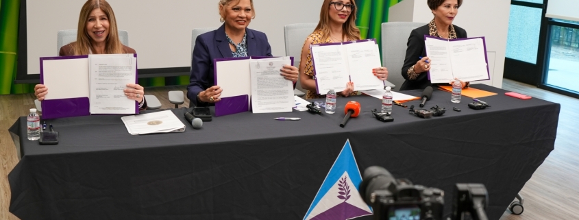 Foto de las cuatro representantes deteniendo el documento del MOU sentadas en una mesa de One Safe Place: El Centro de Justicia Familiar del Sur del Condado.