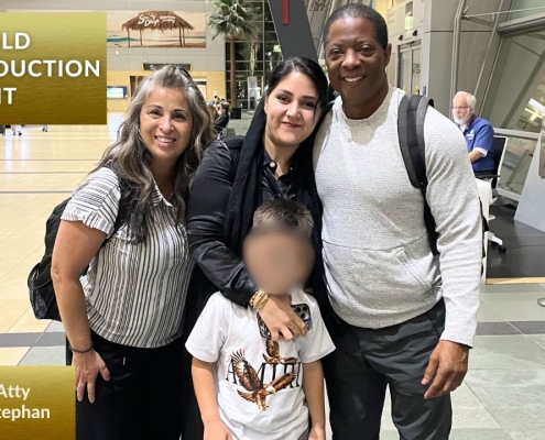 Photo of Child Abduction Unit team with recovered child at airport reunited with mother.