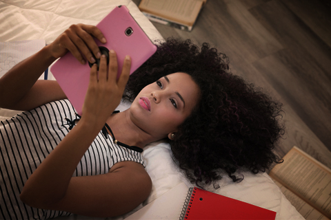 Teen on her iPad in her bedroom. How to keep children safe online.